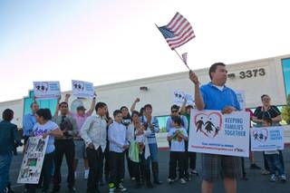 Martin Martinez, who is fighting for a petition for residency in the United States, stands with a large group of protesters in front of a local ICE office demanding action on immigration reform, Wednesday April 10, 2013.